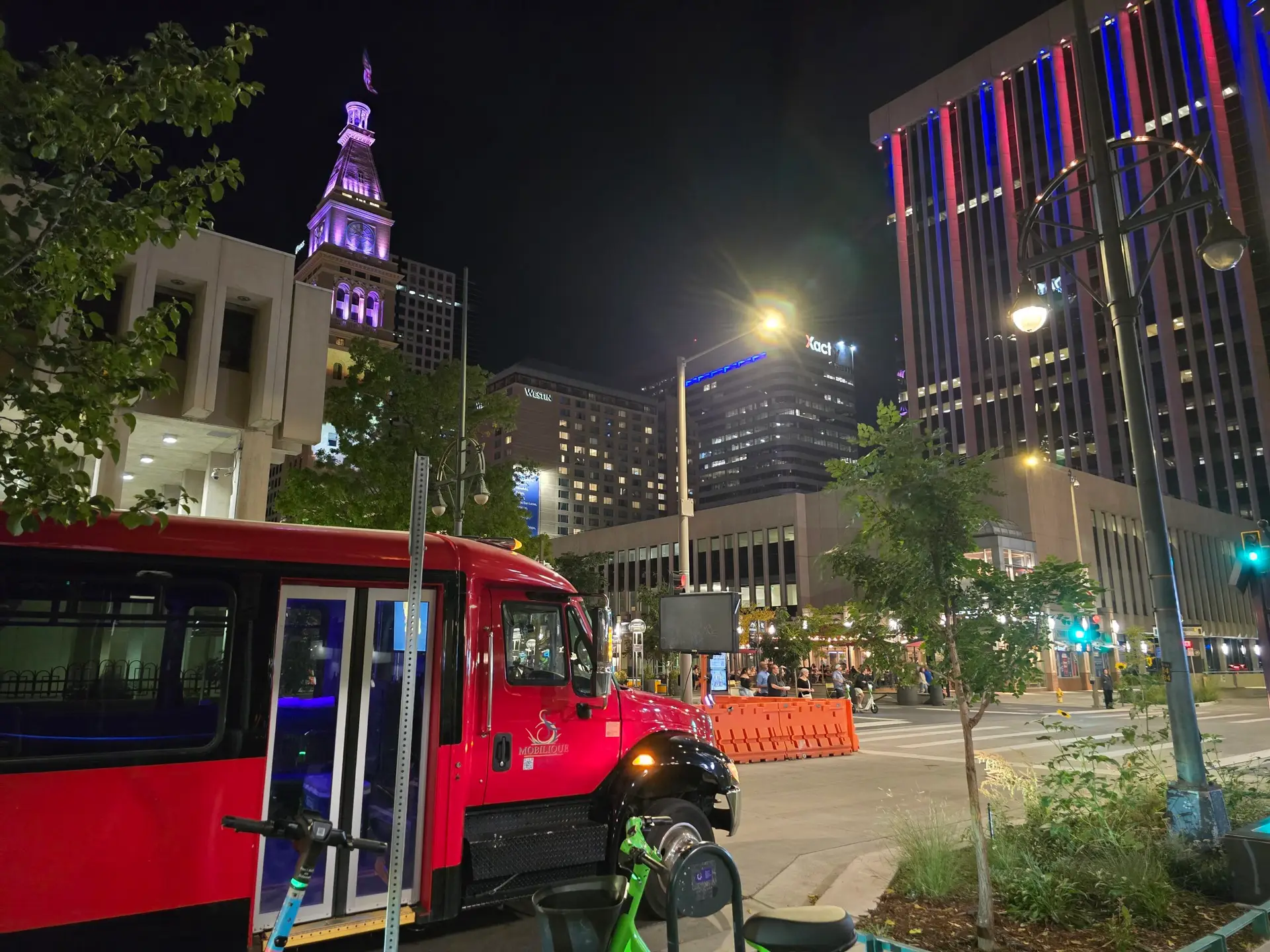 Red party bus at night with the Clocktower lit up in the background
