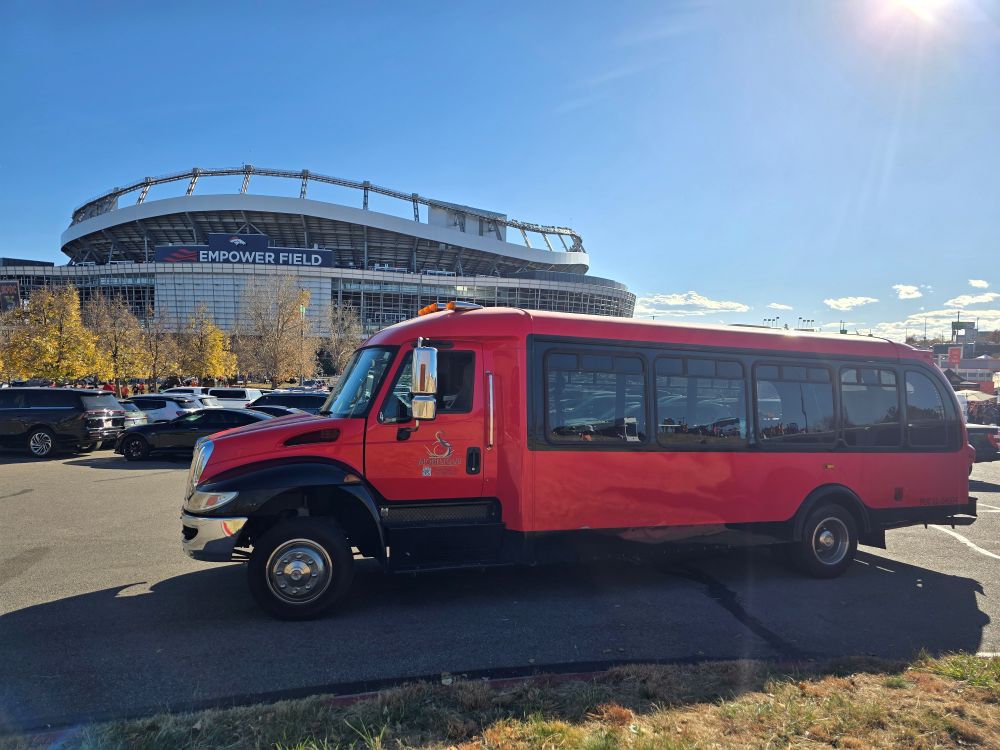 Red limo party bus in front of Denver Empower Field
