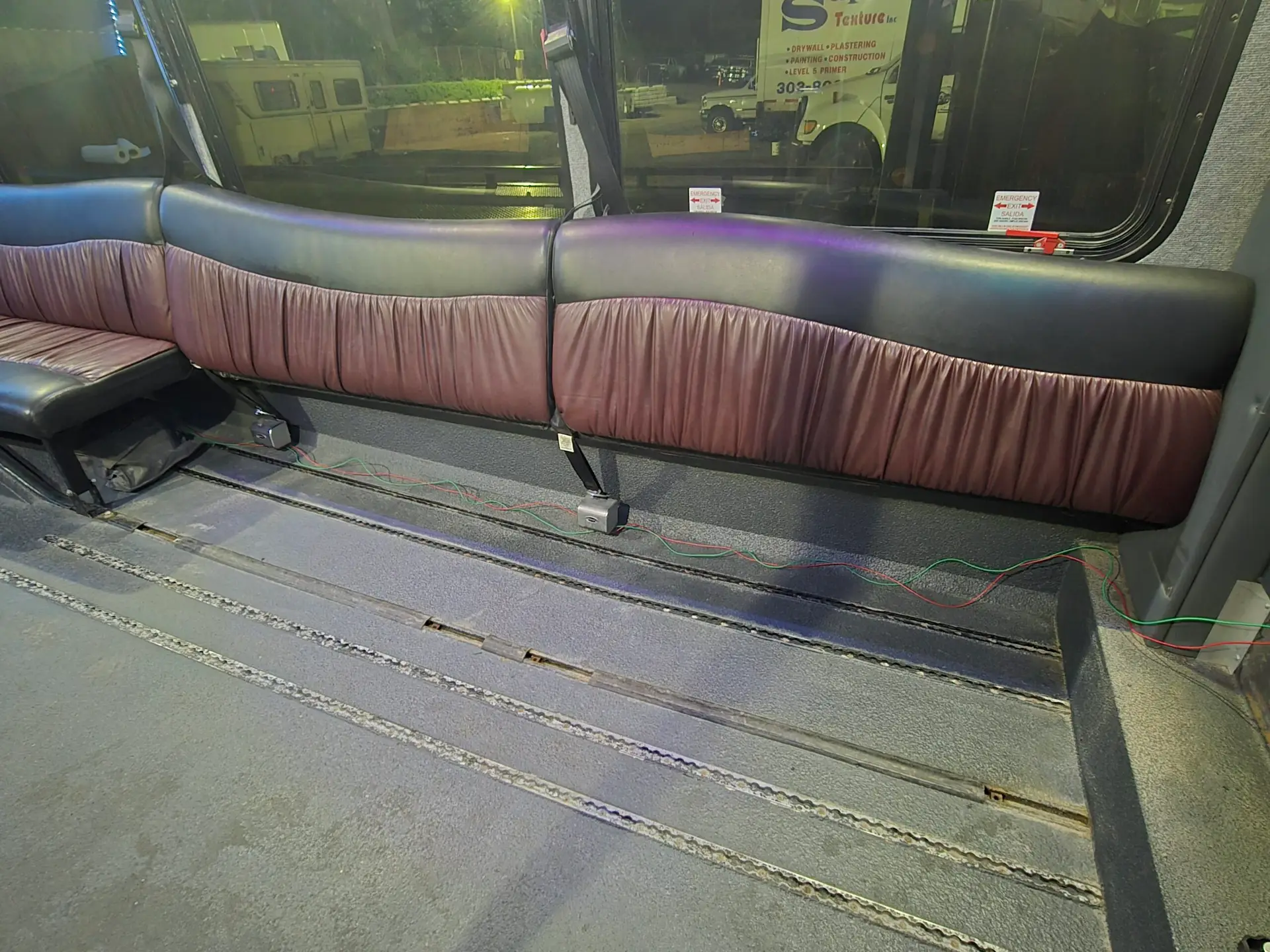 Two section of black and brown limo seating are removed leaving space for two wheelchairs
