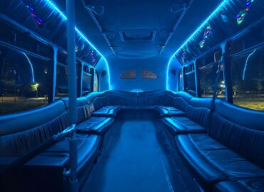 Interior of a limo bus, looking to the rear. The party lights and blue strip lights run the length of the bus on the ceiling
