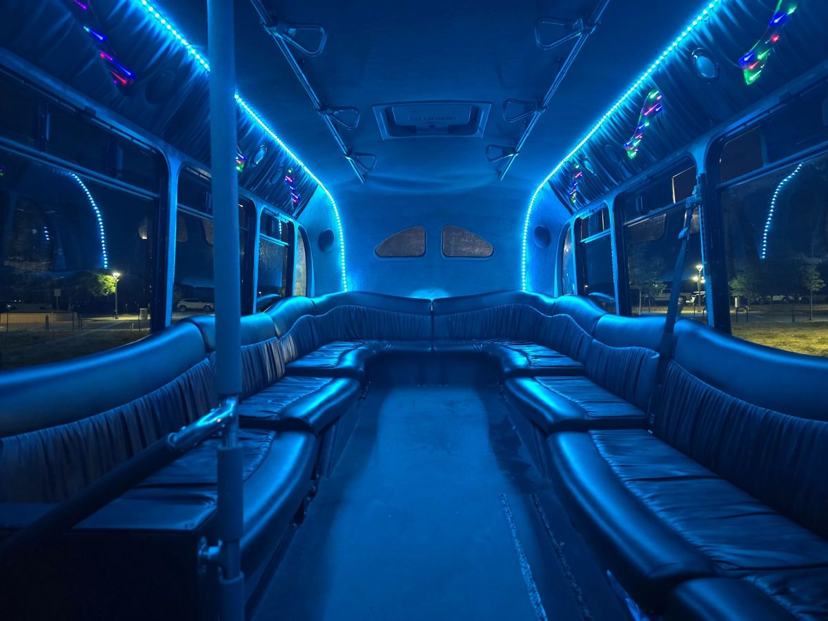Interior of a limo bus, looking to the rear. The party lights and blue strip lights run the length of the bus on the ceiling